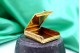 Fosforeira em ouro com relevos gomados e cabochão grenat no fecho de abrir